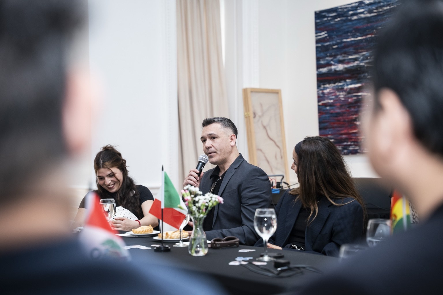 Diego Solari participa con un micrófono en un encuentro en el consulado
